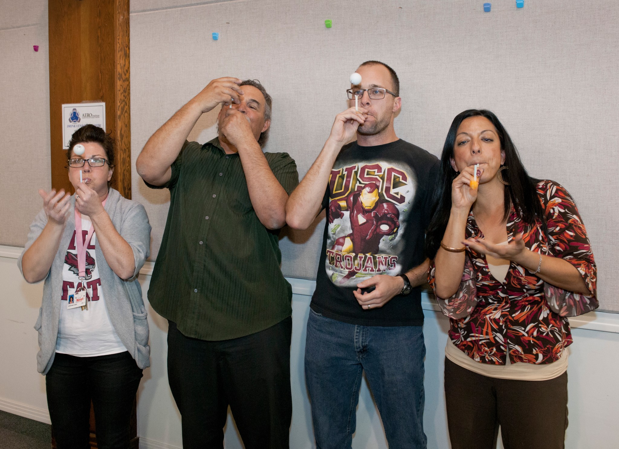 Educators use a straw for a steady air stream making the balls appear to be floating because slower moving air exerts more press