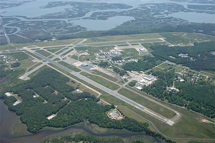 An aerial photo of Wallops Flight Facility's main base, which has two criss-crossing air strips surrounded by green marshlands.
