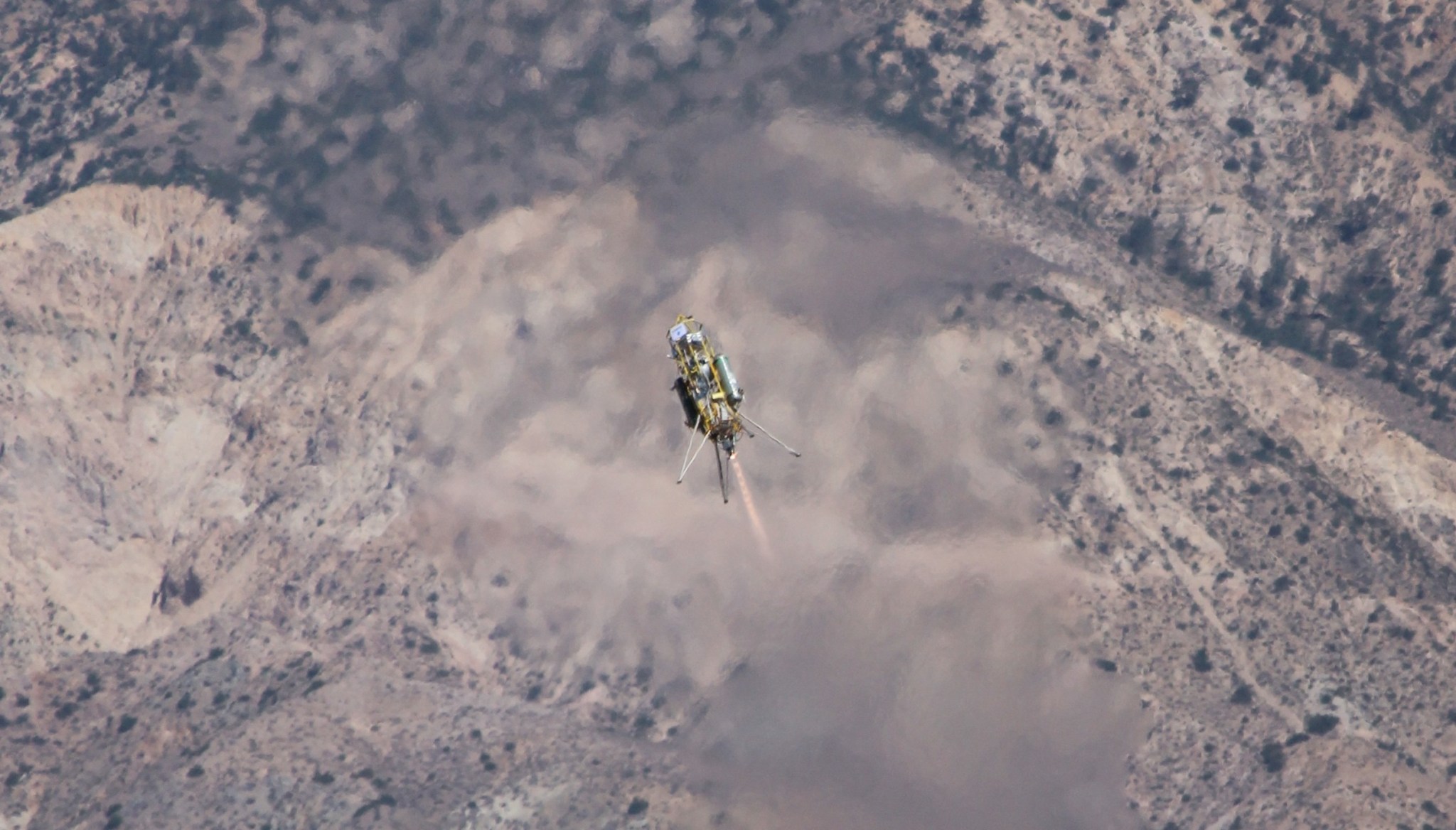 Bird's-eye view of Xombie flying above a hilly desert landscape