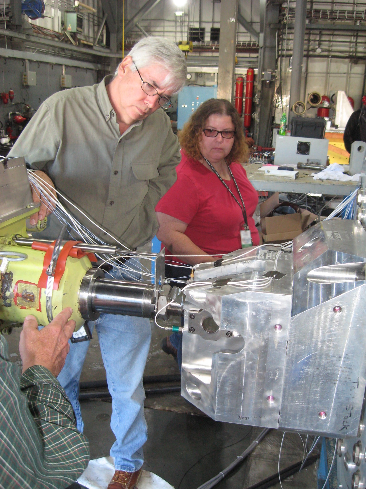 NASA Marshall's Roger Parisa and Miranda Holton get the thrust vector control actuator ready for vibration testing. 