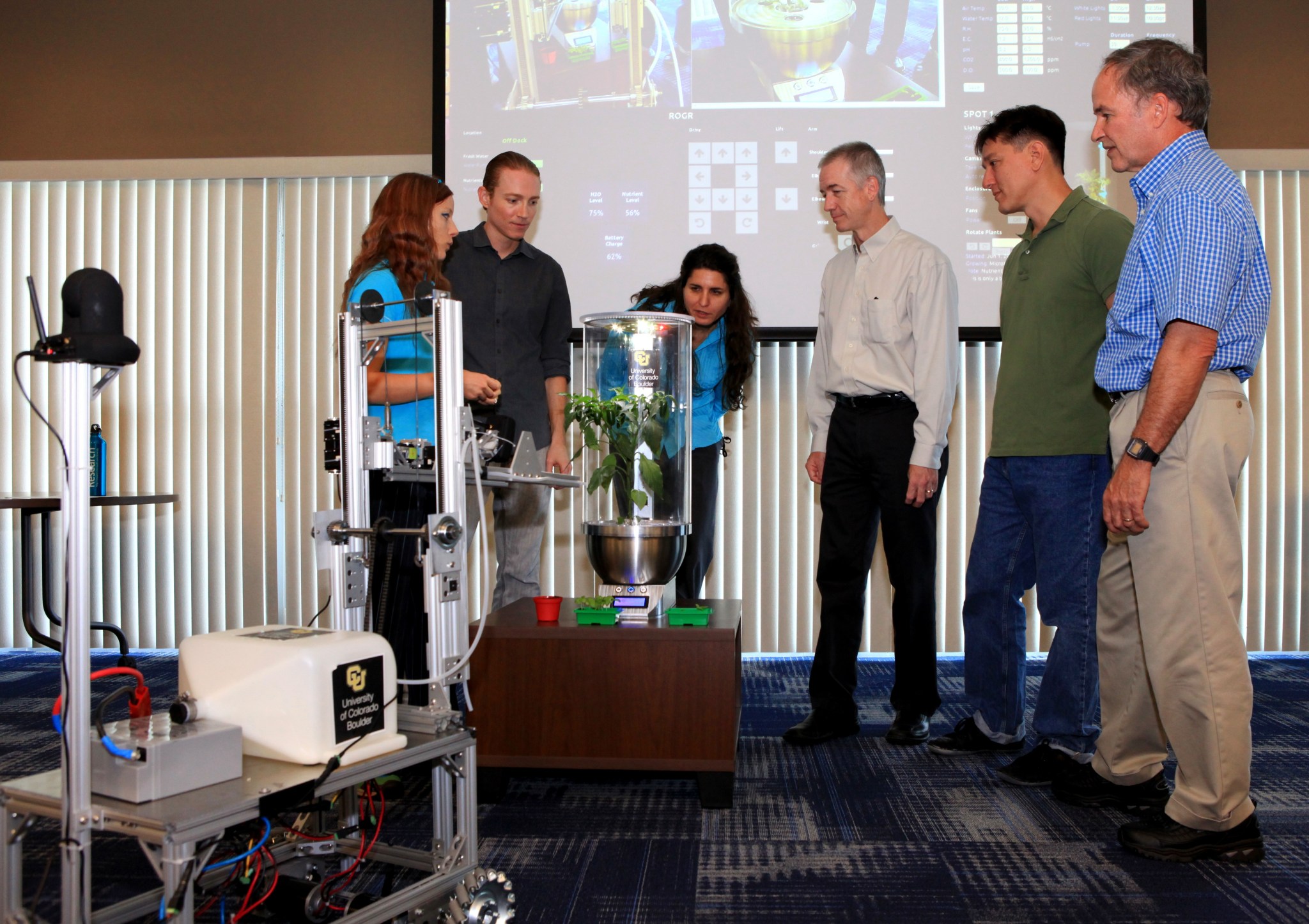University of Colorado Boulder graduate students Heather Hava, far left, and Daniel Zukowski, second from the left, describe a computerized SmartPot, or SPOT, which could be used to grow plants in a deep-space habitat.