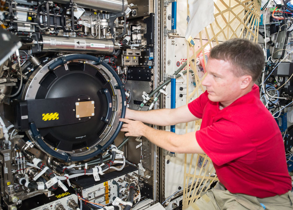 NASA astronaut Terry Virts works with the SPINSAT