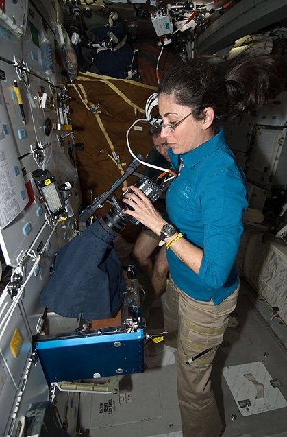 STS-133 Mission Specialist Nicole Stott uses a video camera to record data for the Mouse Immunology-2 investigation aboard space