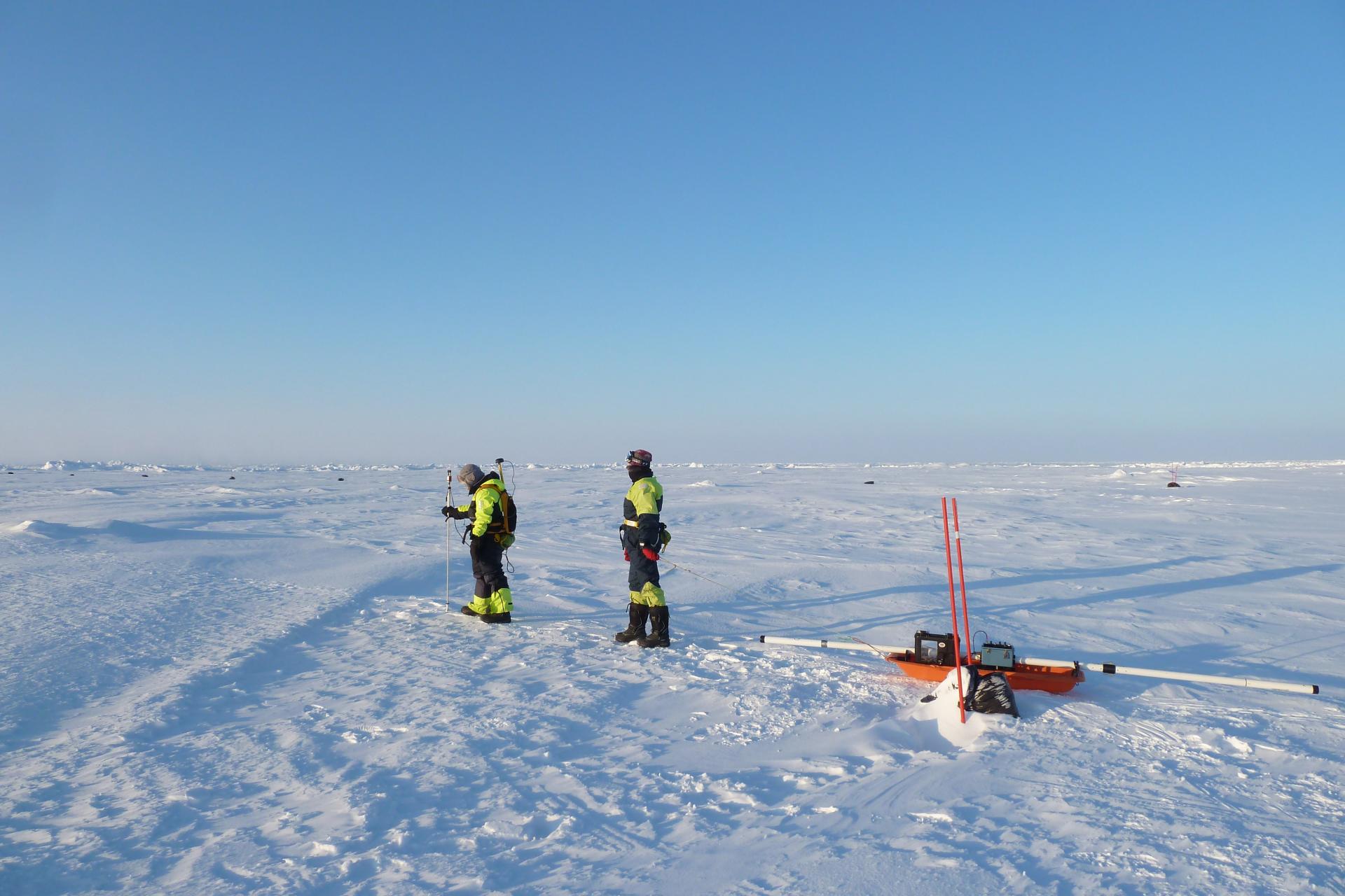Field scientists measure snow and ice thickness along a survey line in preparation for IceBridge's overflight.