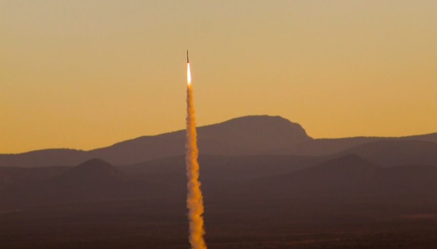 Sounding rocket launch against a mountain landscape and yellow sky
