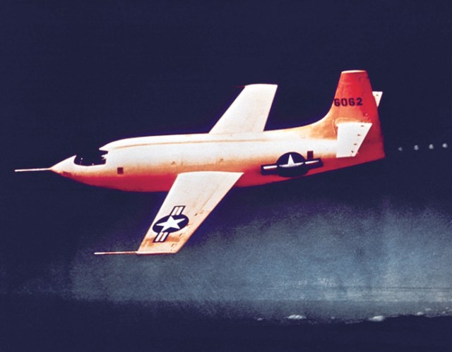 The Bell X-1 painted in a red color is in flight.