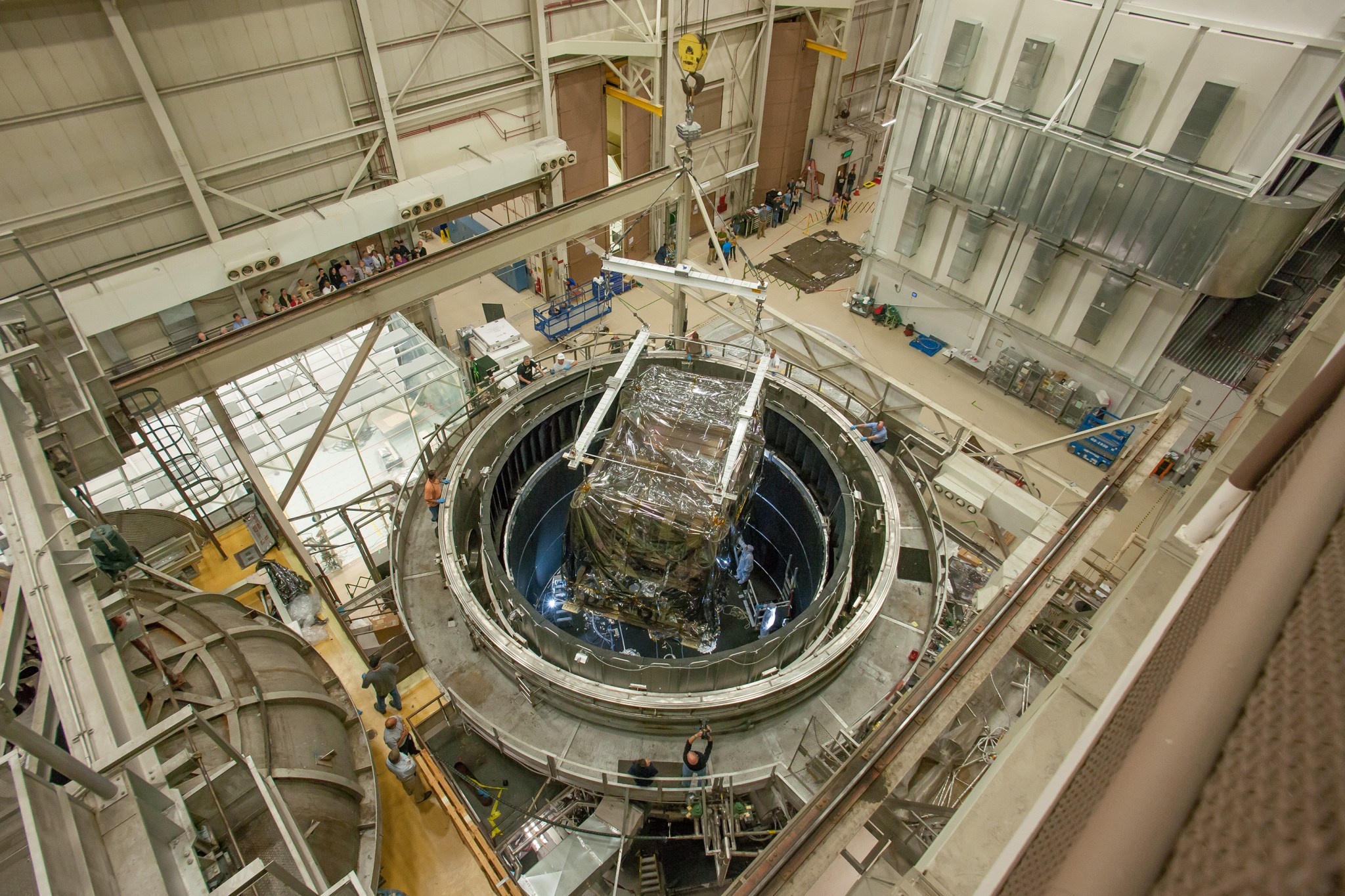 A crane lowers the heart of the James Webb Space Telescope into the Goddard Thermal Vacuum Chamber where it will spend 116 days in a space-like environment.