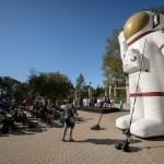 In this view, a giant inflatable model of a spacesuit stands to the right of the audience during an outdoor event at the Chabot Space and Science Center.