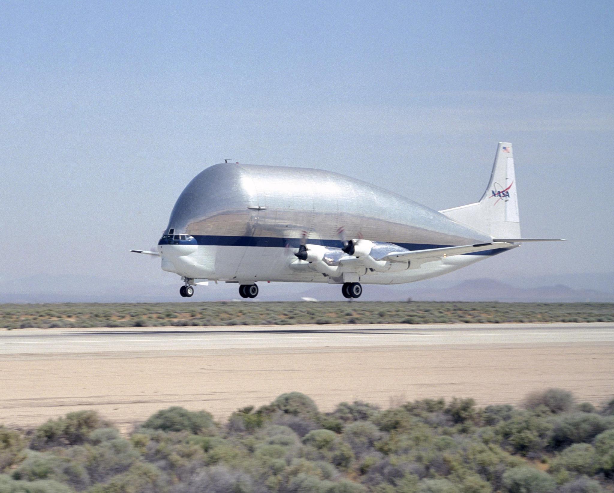 The Super Guppy airplane, with an extended body, lands on a runway
