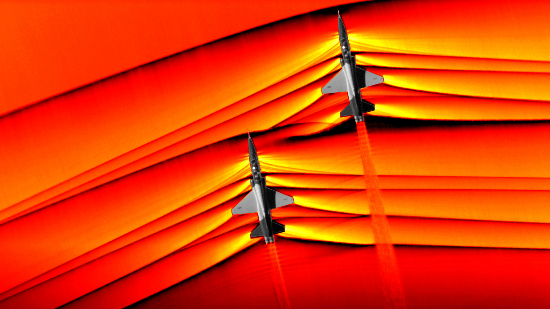 Schlieren photography capturing shockwaves from two supersonic aircraft flying in formation.