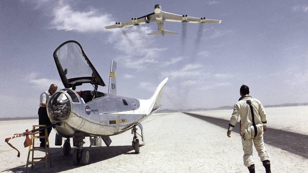 NASA research pilot Bill Dana watches NASA's NB-52B cruise overhead after his flight in the HL-10.
