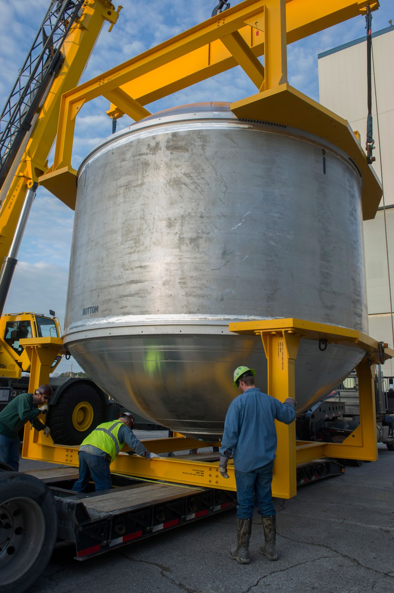 A massive cryogenic tank is loaded onto a truck at NASA's Marshall Space Flight Center.