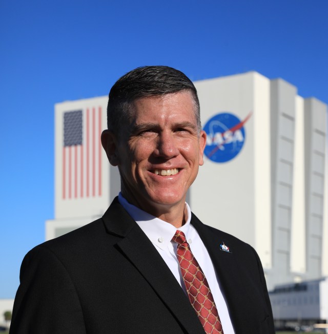 A photo of Kennedy Space Center's Jeremy Graeber with the Vehicle Assembly Building in the background.