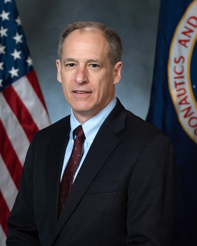Portrait of Bryan K. Smith, with U.S. and NASA Flags in background.