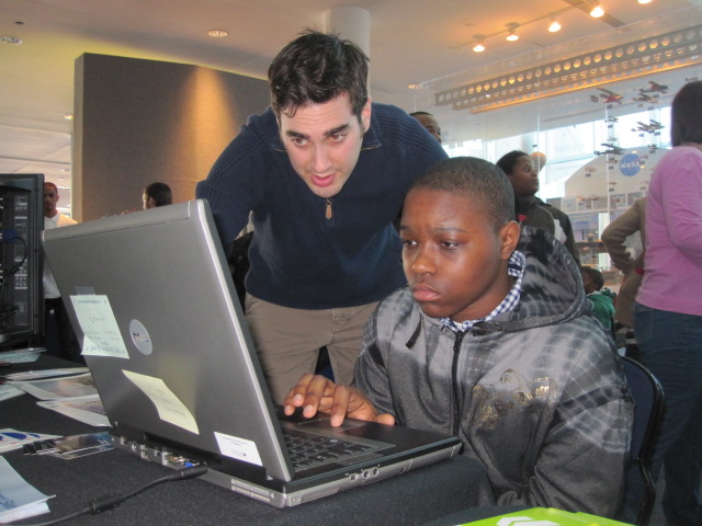 Kevin Coyne helping a student who is sitting at a computer.