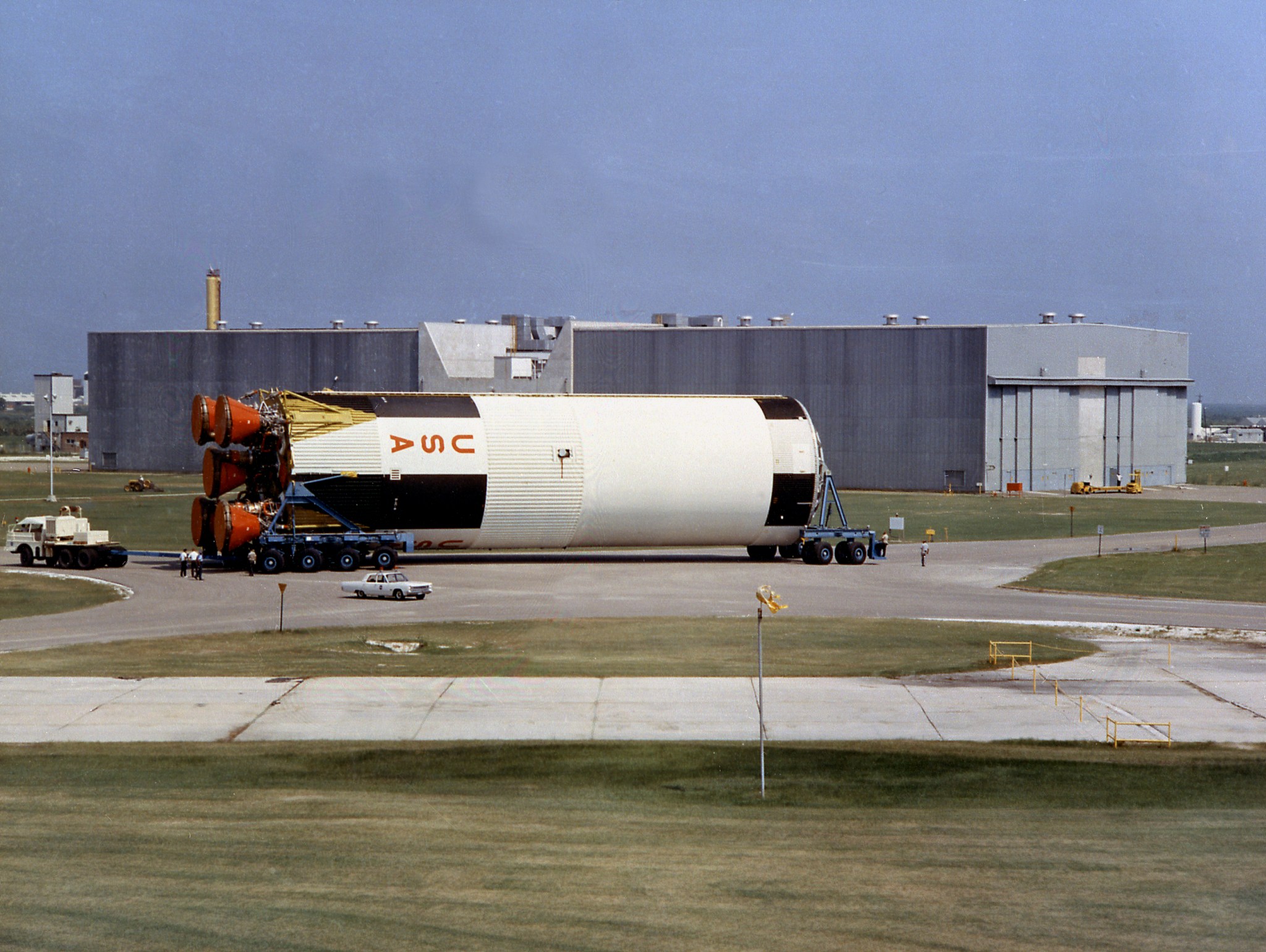 A completed S-IC flight stage is transferred in the summer of 1968 from the vehicle assembly building to the stage test building at the Michoud Assembly Facility.