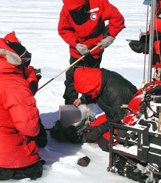 Scientists in red jackets conducting an experiment on the ice