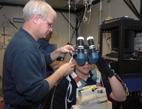 Human setting up a virtual reality device on a young man's head