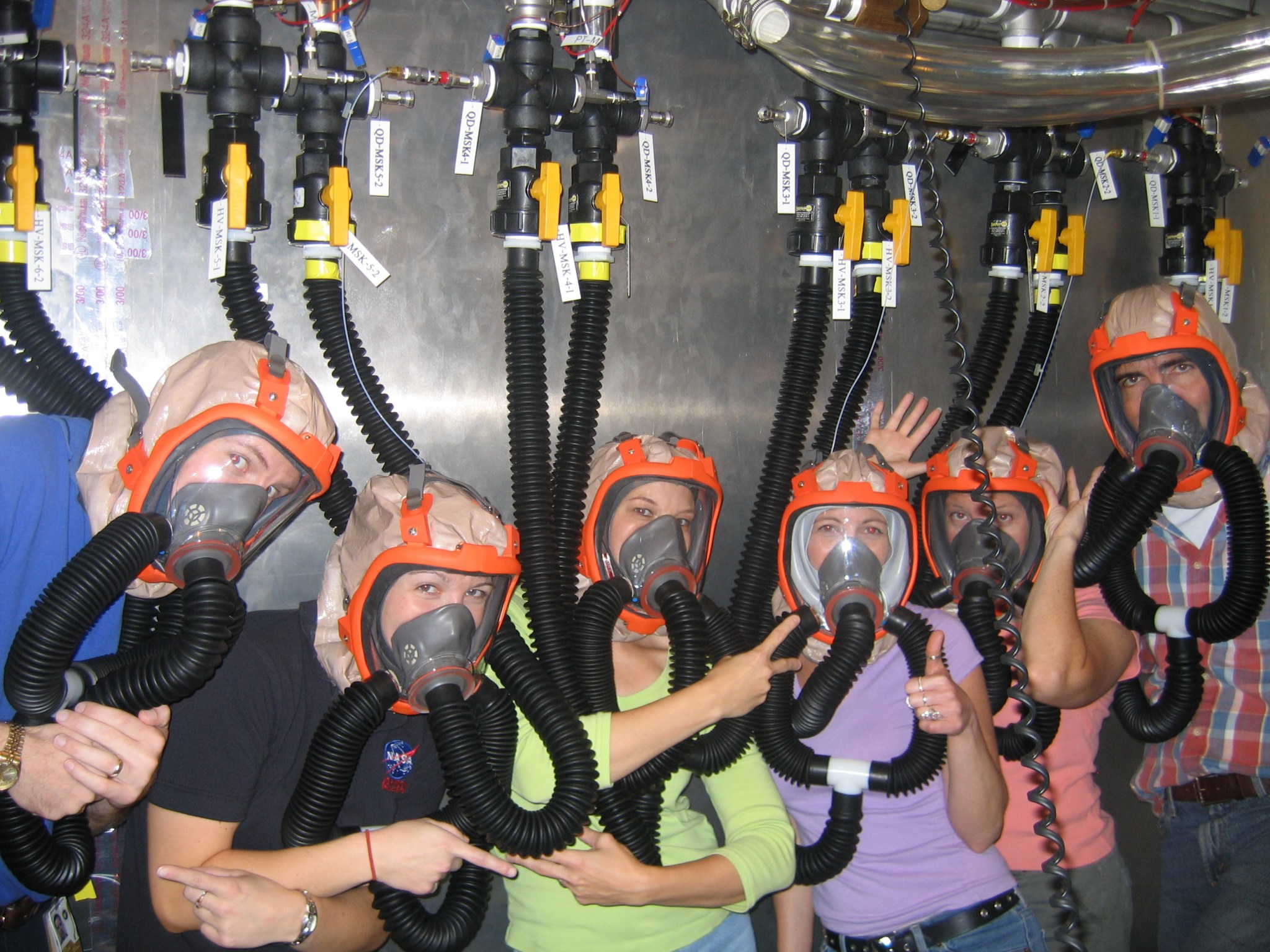 Six test subjects wearing respiratory masks in altitude chamber