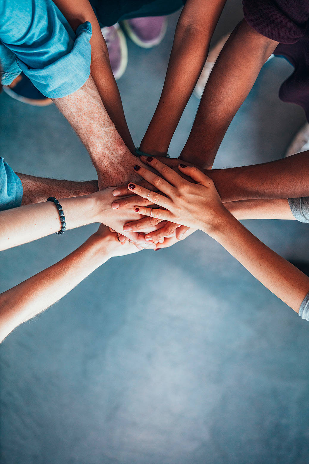 team members stack hands in a huddle