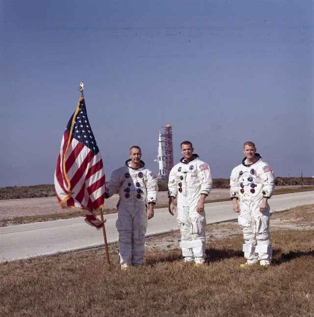 The Apollo 9 astronauts, left to right, James A. McDivitt, David R. Scott, and Russell L. Schweickart, pose for a photo in front of the Saturn V rocket at Kennedy Space Center