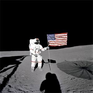 Astronaut Alan Shepard holding the American flag on the lunar surface