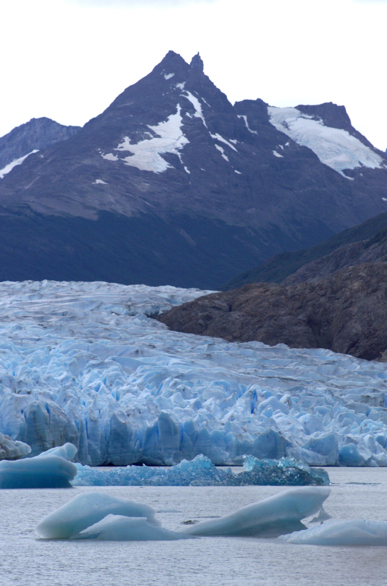 An image of a large Glacier with snowy mountains in the background.