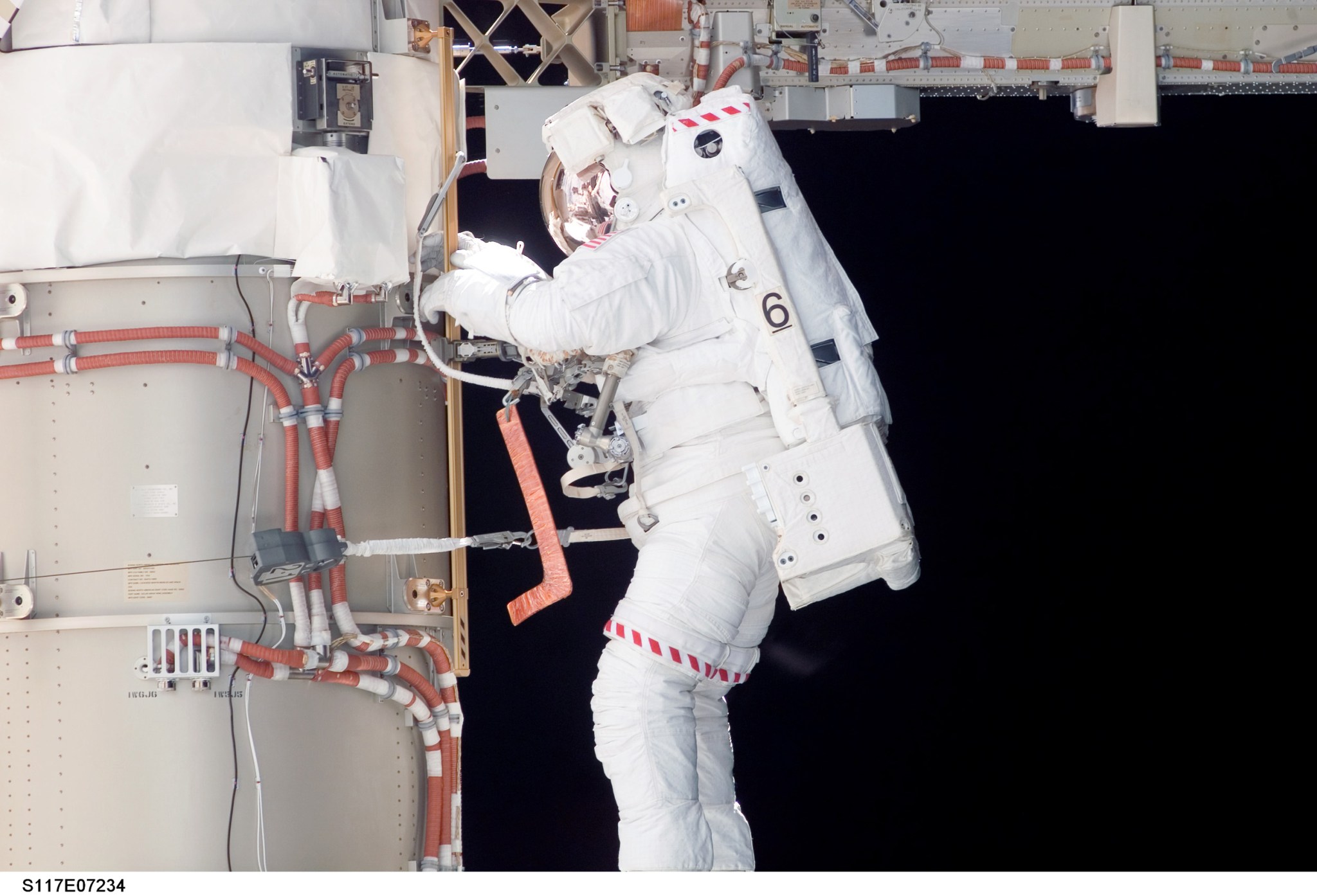 Steven Swanson completes a spacewalk outside the International Space Station while wearing a spacesuit