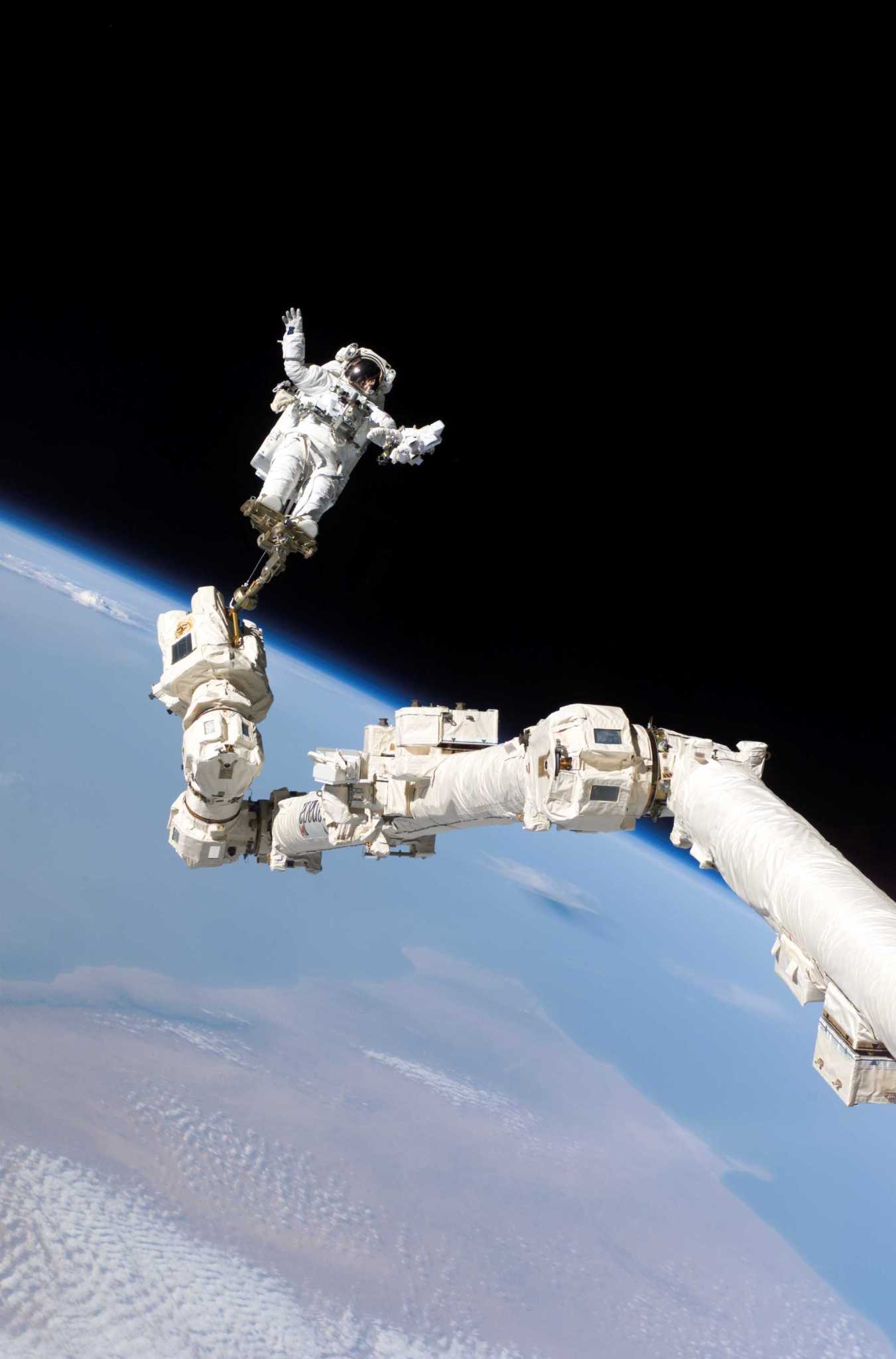 An astronaut is anchored to a foot restraint on the International Space Station's Canadarm2