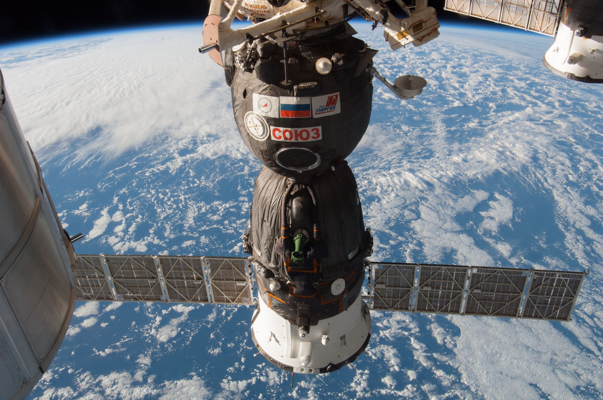 Soyuz spacecraft attached to the space station above Earth