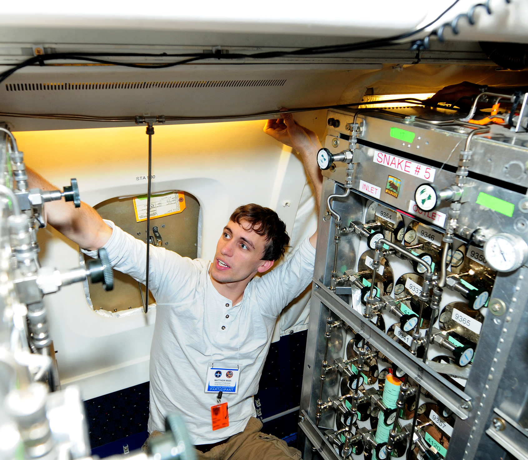 Matthew Irish, a senior Climate Impact Engineering major at the University of Michigan, attaches tubing to the Whole Air Sampler