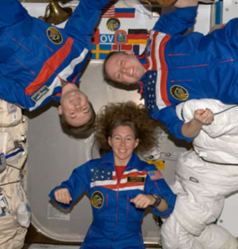 3 astronauts floating in microgravity