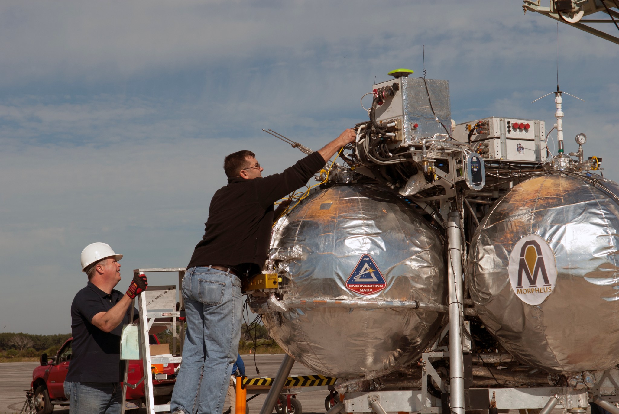 Engineers make adjustments to the Morpheus prototype lander.