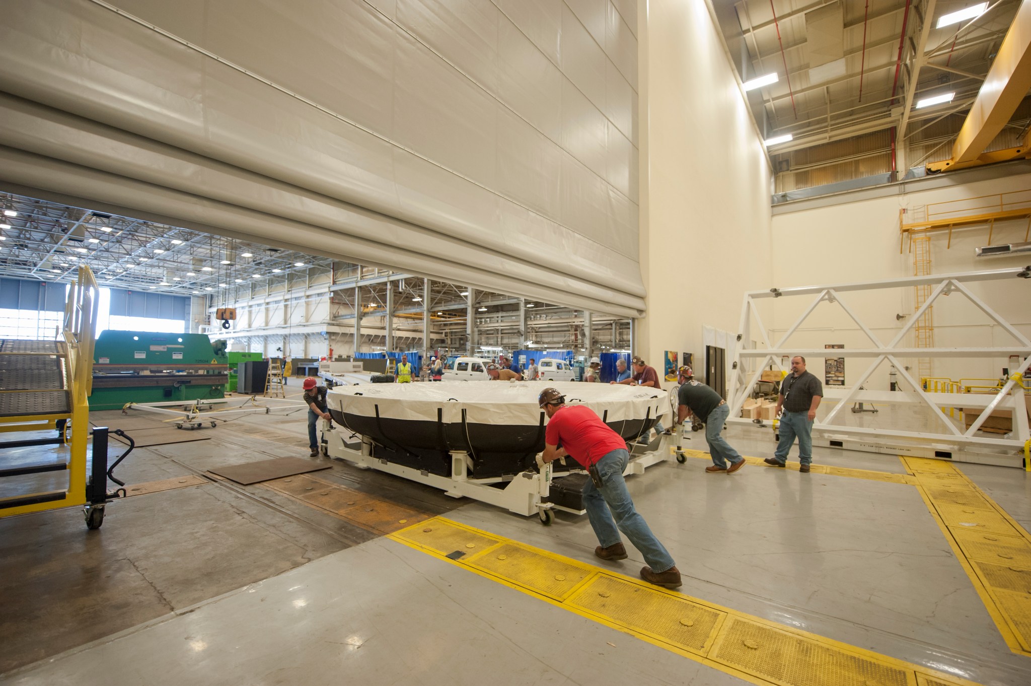Workers at Marshall move the Orion heat shield -- packed for interstate travel by truck -- out of Building 4705. 