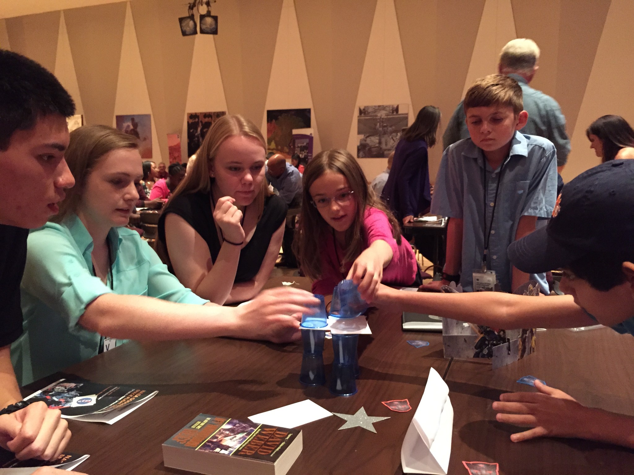 young people stack cups on a table