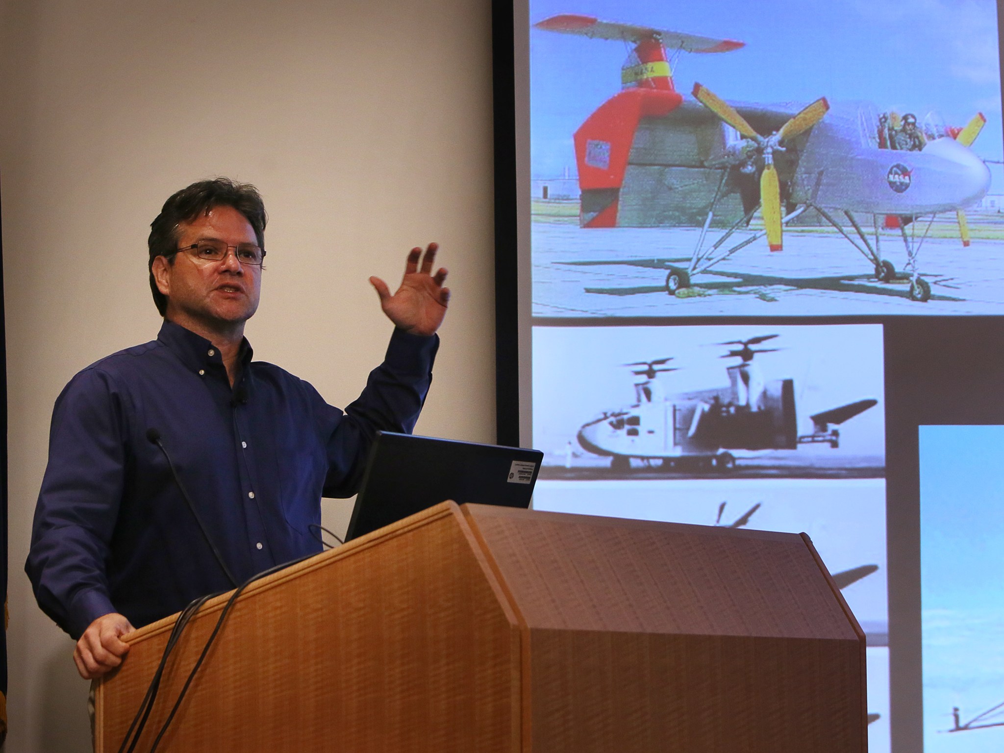 Mark Moore standing at a podium giving a talk on VTOL aircraft.