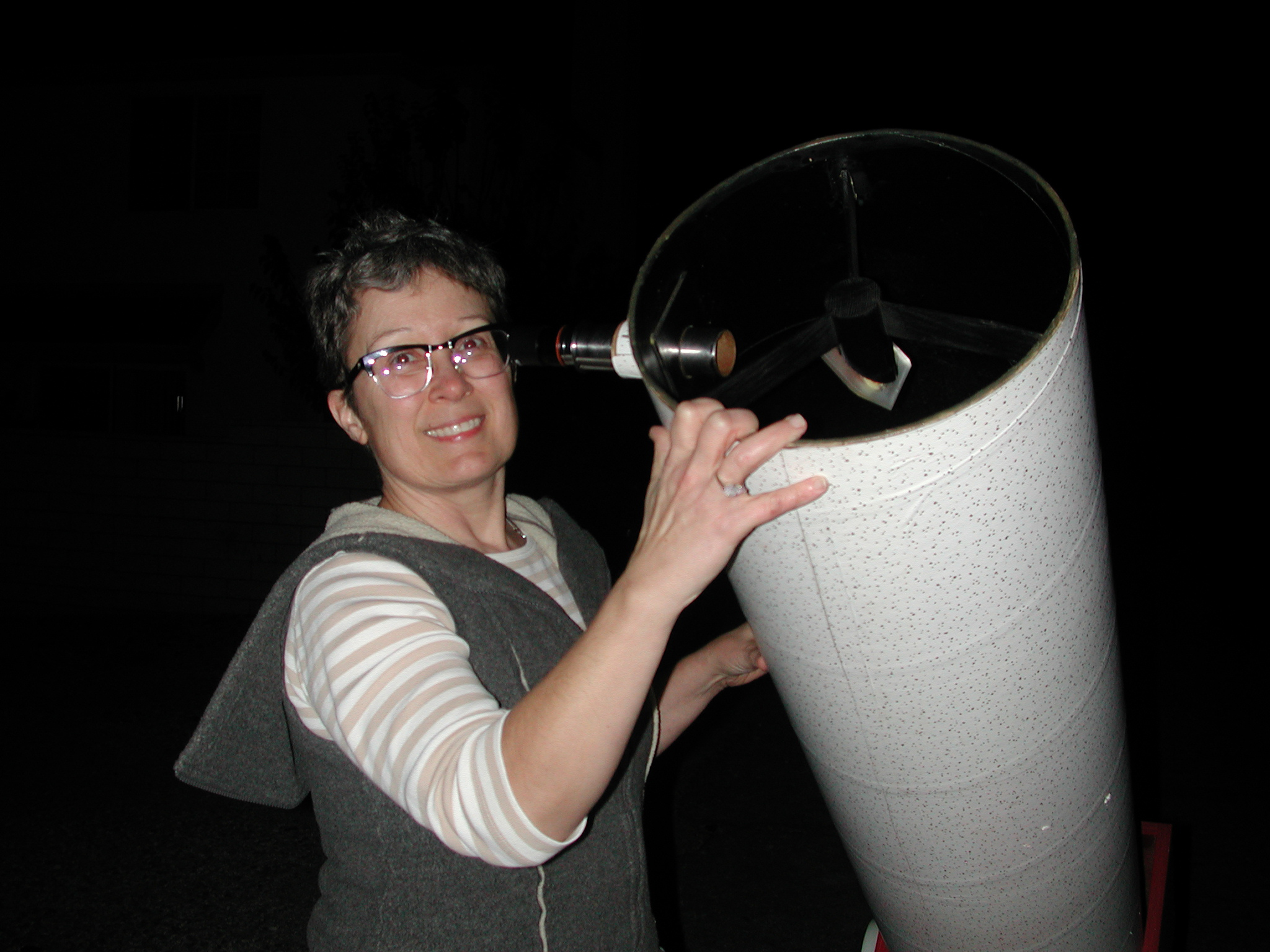 A woman holding up one end of a homemade telescope
