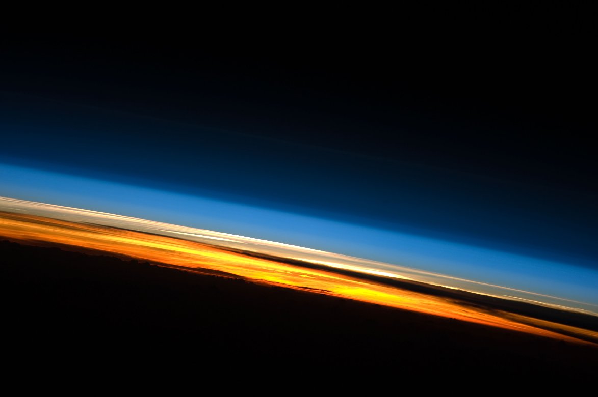 Colorful view of Earth's atmosphere looking across Earth's surface from the space station