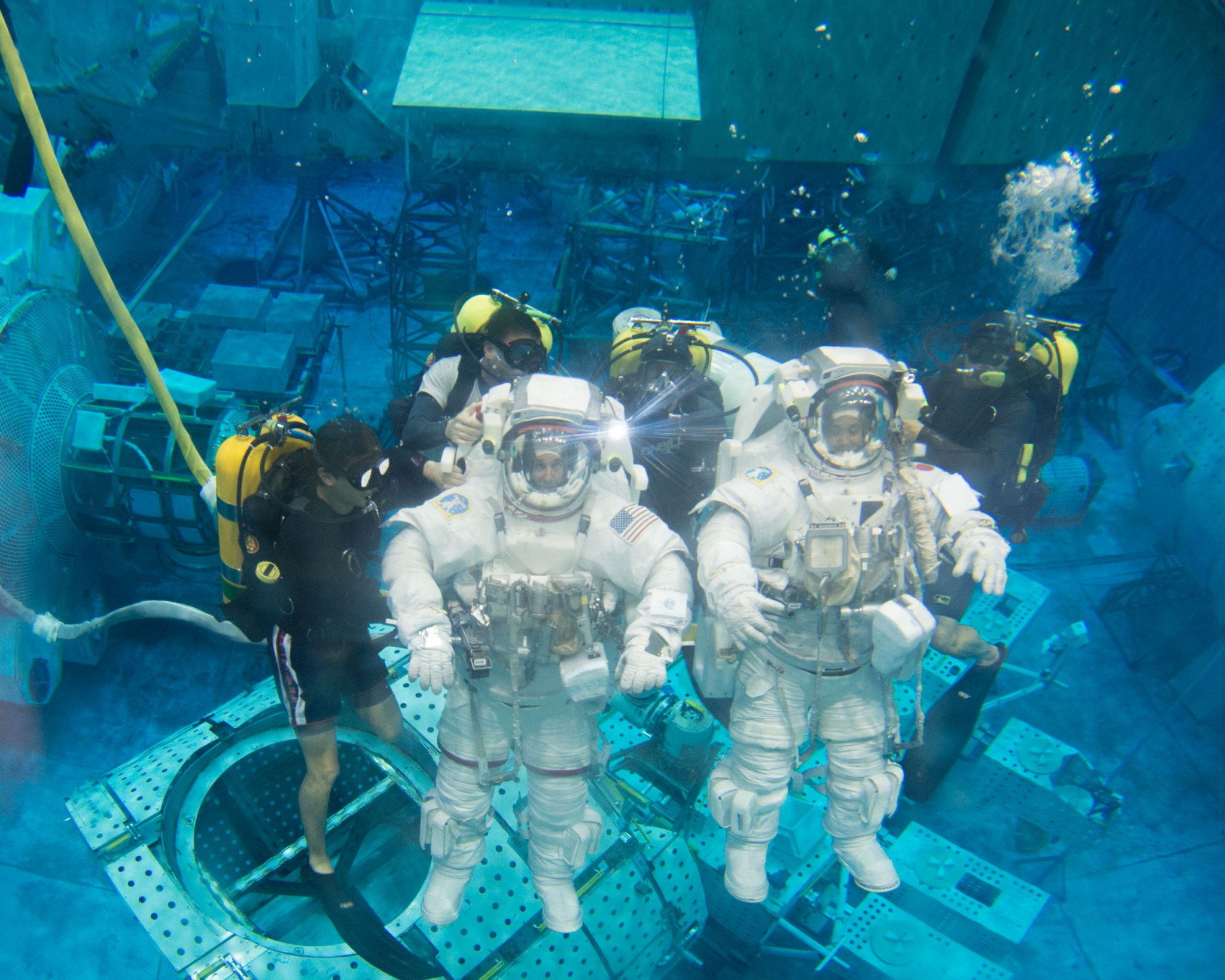 Two astronauts train for spacewalking while going underwater in the Neutral Buoyancy Laboratory