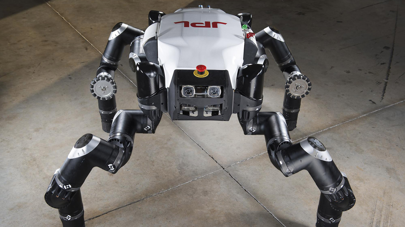 Robot with four black legs and the three red letters JPL on its white-colored back