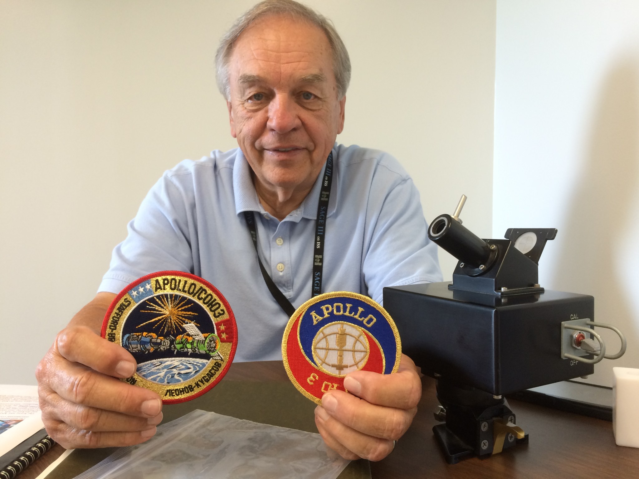 Pat McCormick shows off patches from the Apollo-Soyuz Test Project.