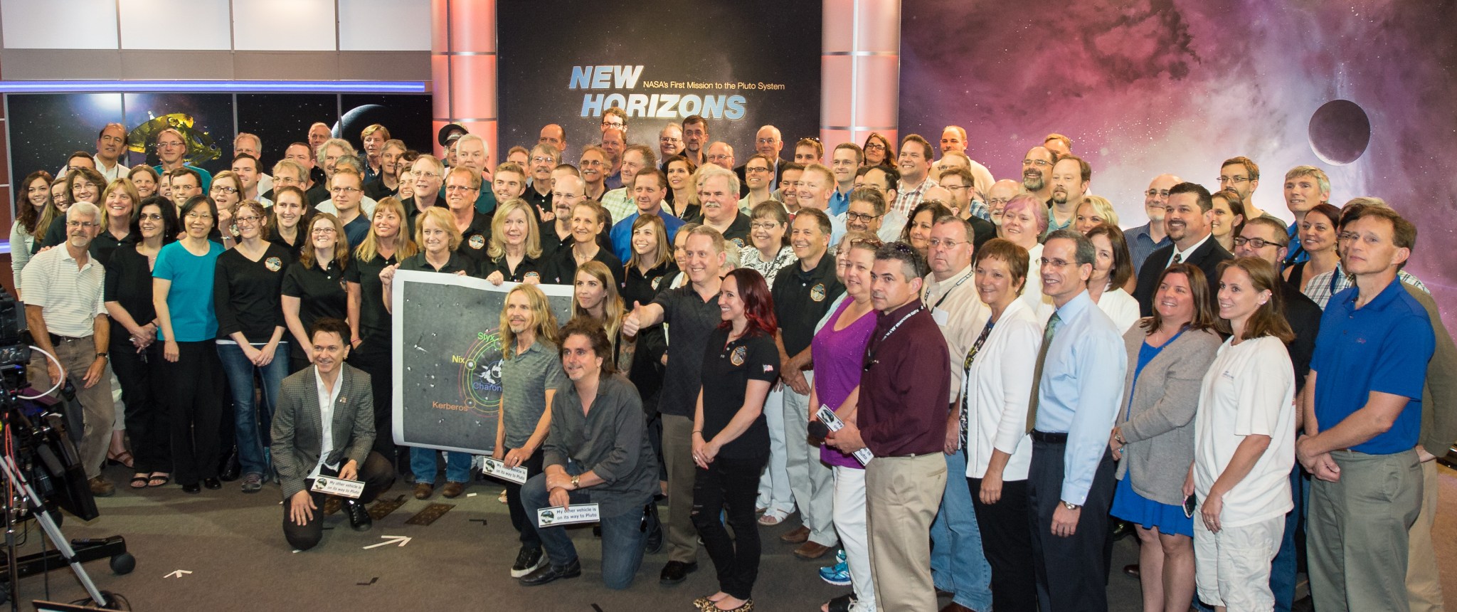 Styx poses with members of the New Horizons mission team