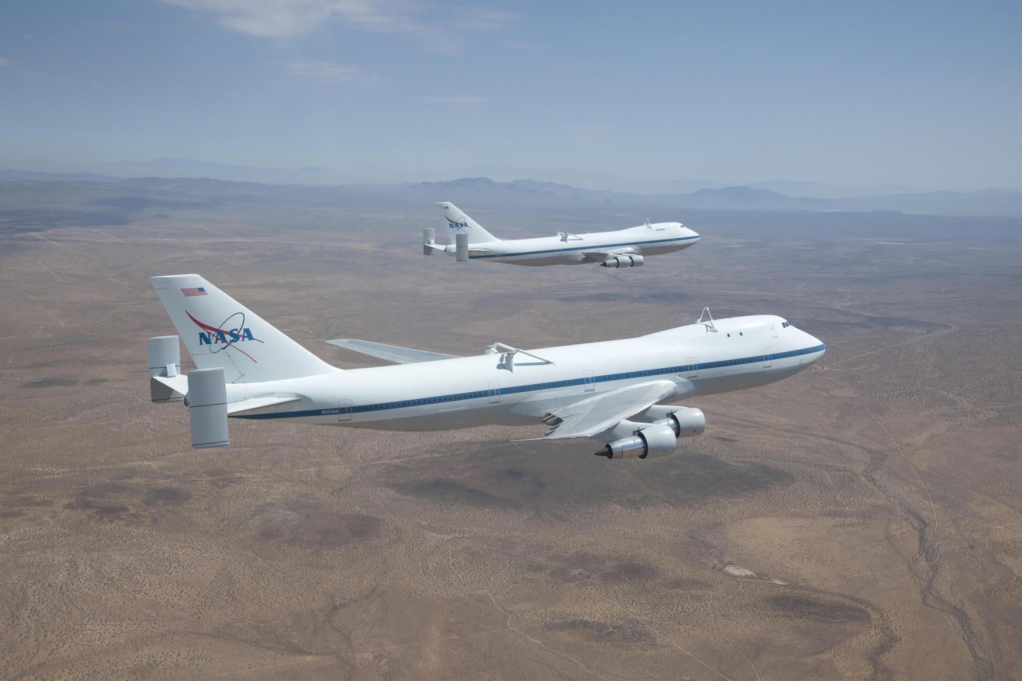NASA's two 747 shuttle carrier aircraft fly in formation over the California desert near Edwards Air Force Base.