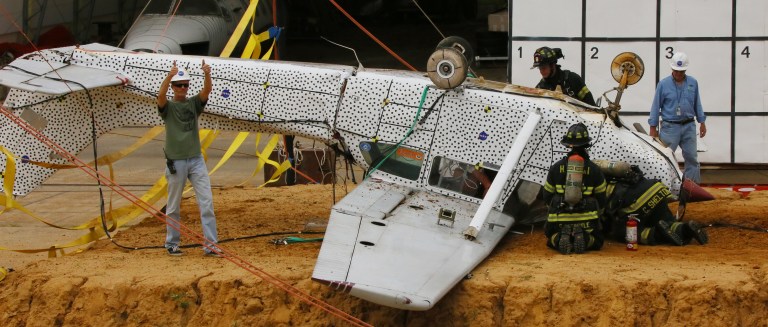 Technicians look over the wreckage of the Cessna 172 following the crash test.