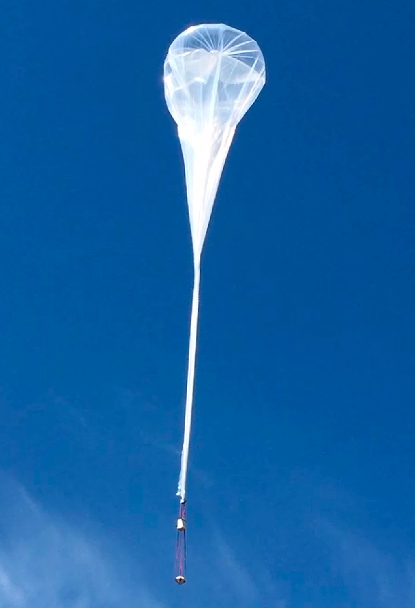 High-altitude balloon lifts space reentry capsule for flight test.