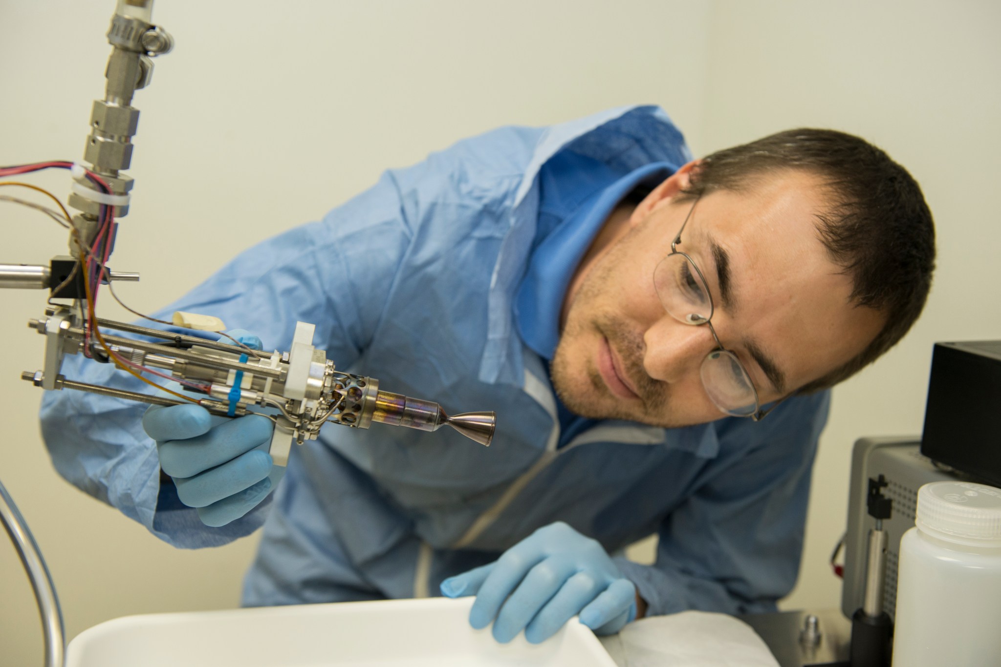  Engineer Chris Burnside examines a smaller 5 Newton thruster that also was tested at NASA’s Marshall Space Flight Center.