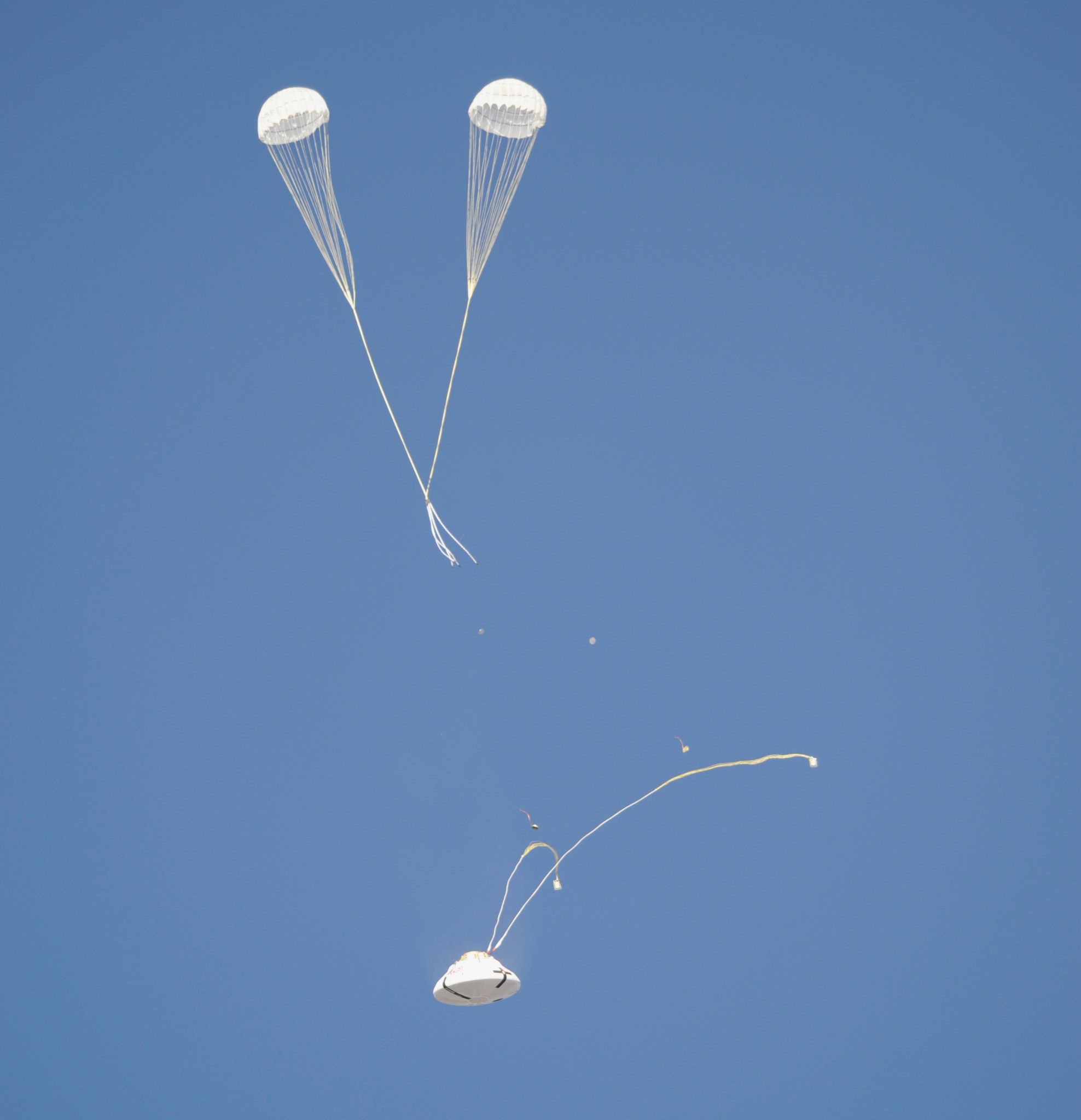 The Orion parachute system enters another phase of its descent from a C-17 aircraft.