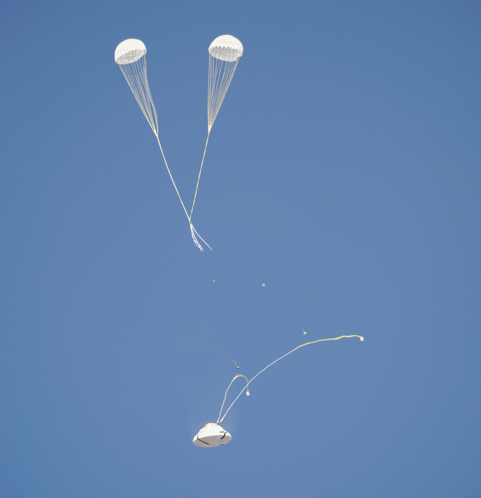 The Orion parachute system enters another phase of its descent from a C-17 aircraft.