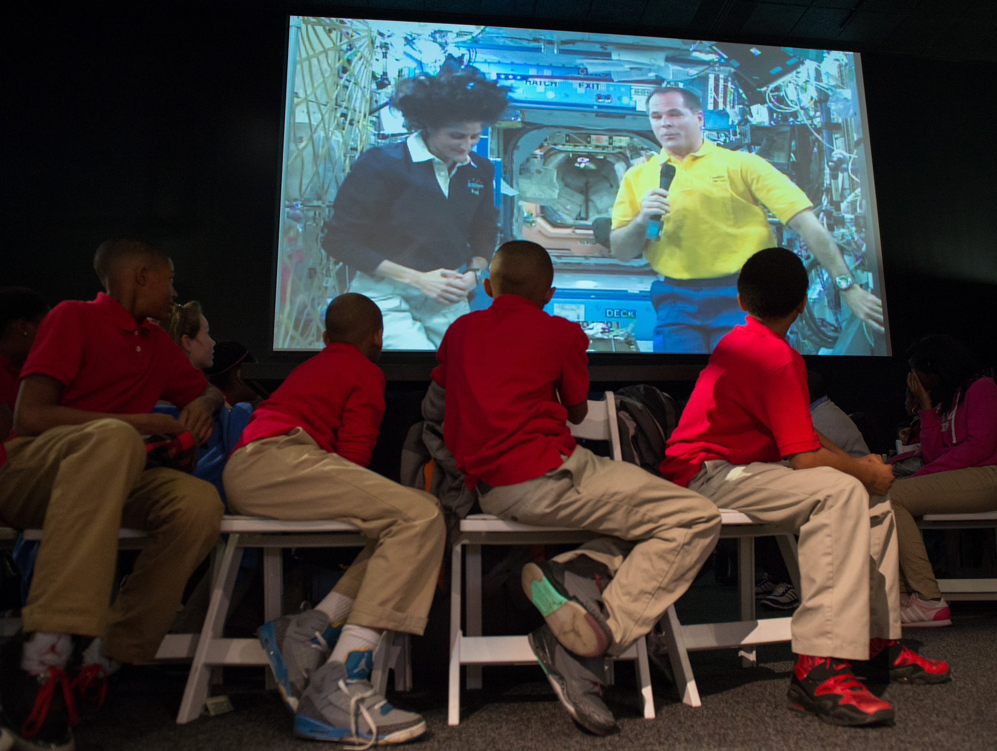 International Space Station Expedition 33 crew (on screen) answers questions from students during a downlink event