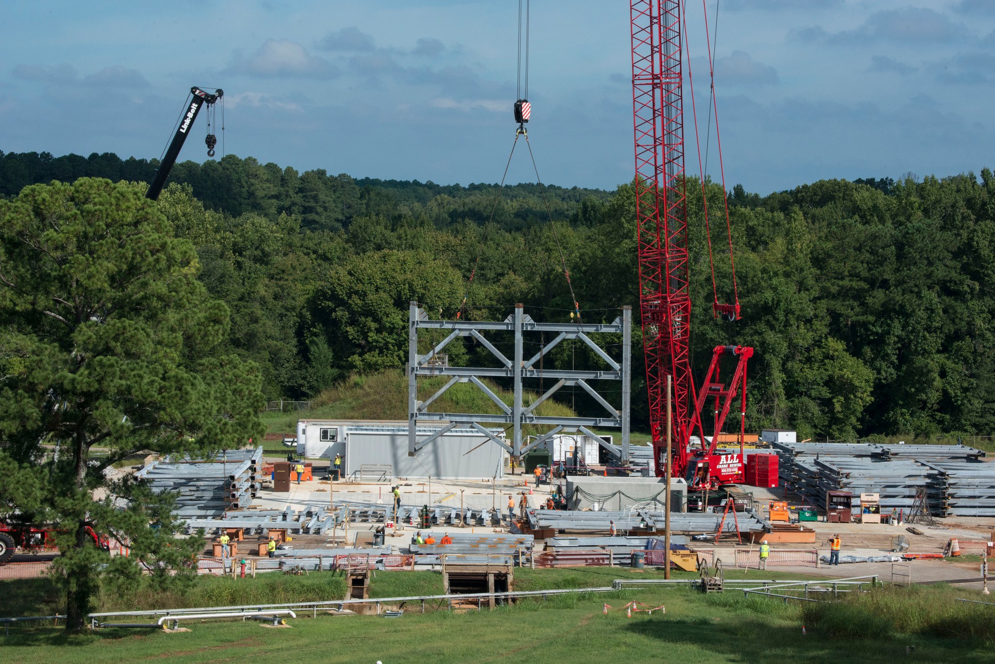 A crane positions the first steel piece for twin towers of a 215-foot-tall structural test stand for NASA's Space Launch System.